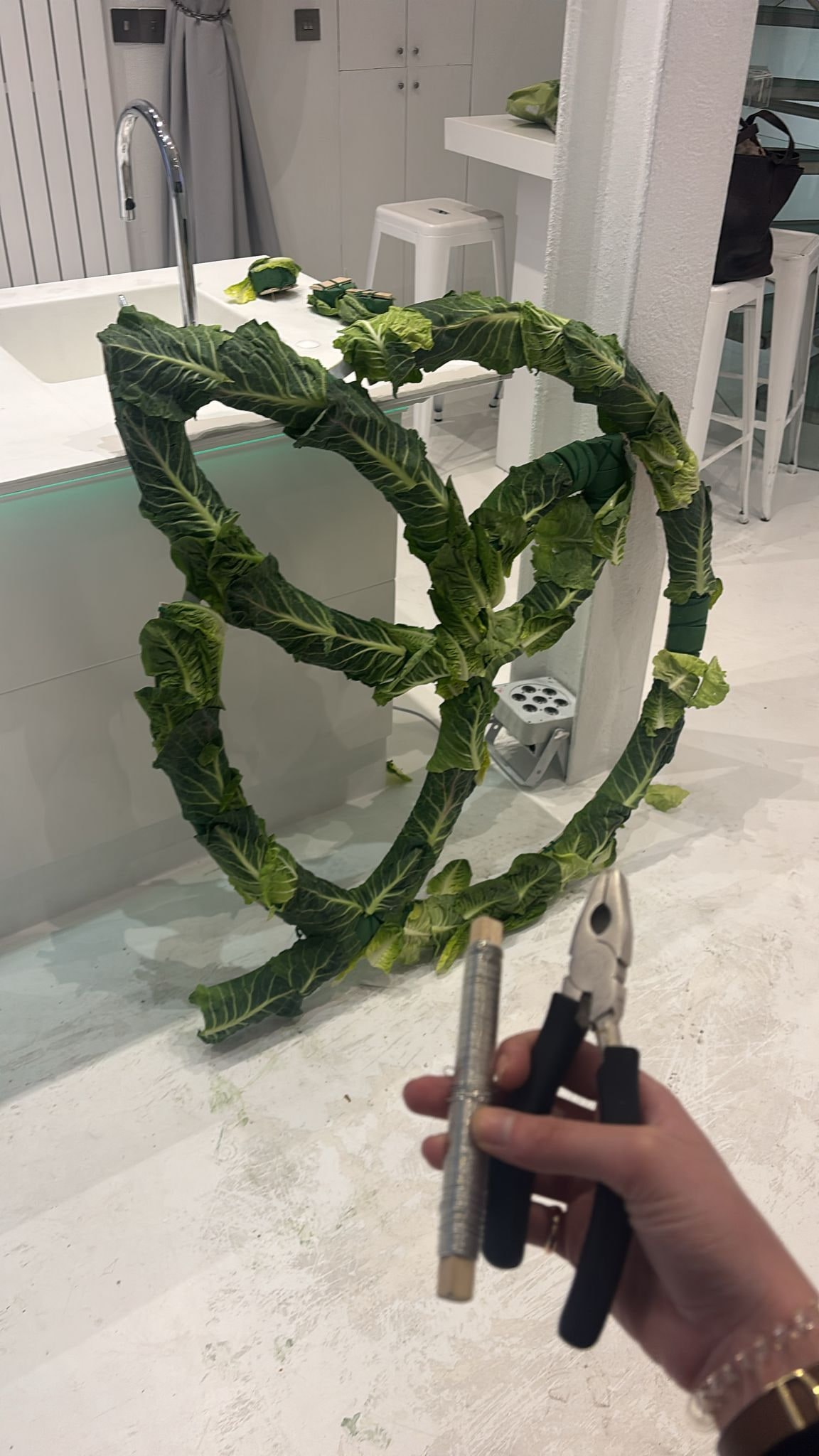 Hands assembling an event logo out of real cabbage leaves