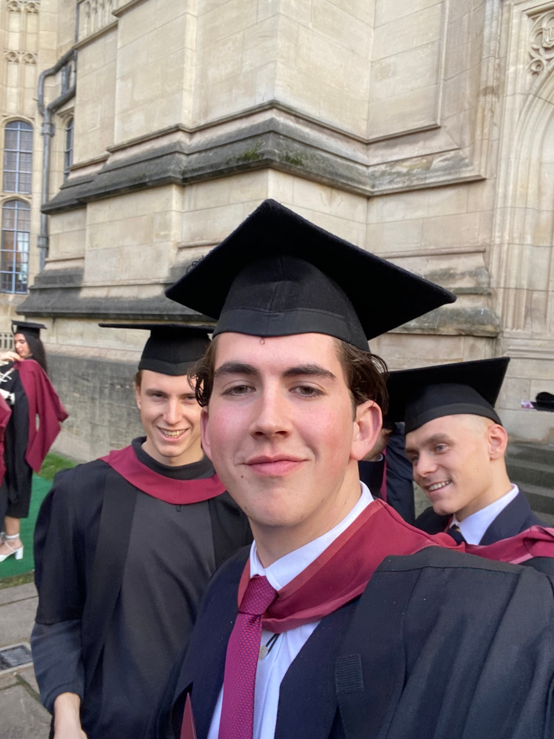 Louis in cap and gown with friends outside the Wills Memorial Building