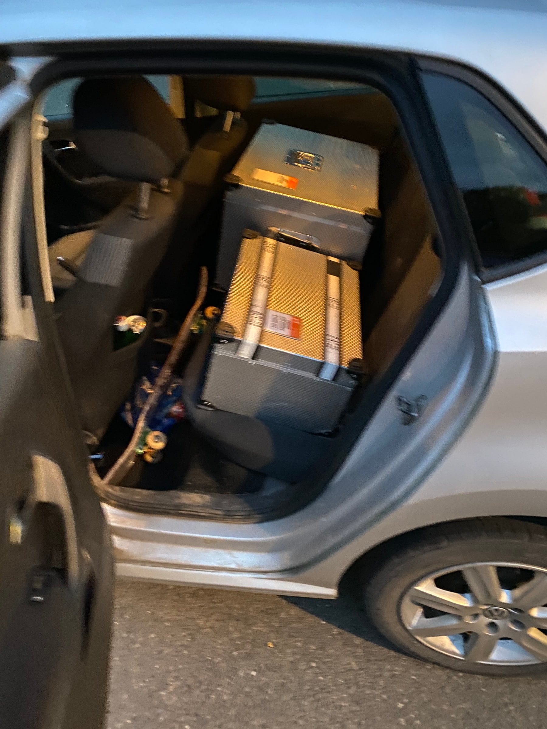 Camera flight cases stacked into the back seat of a small hatchback