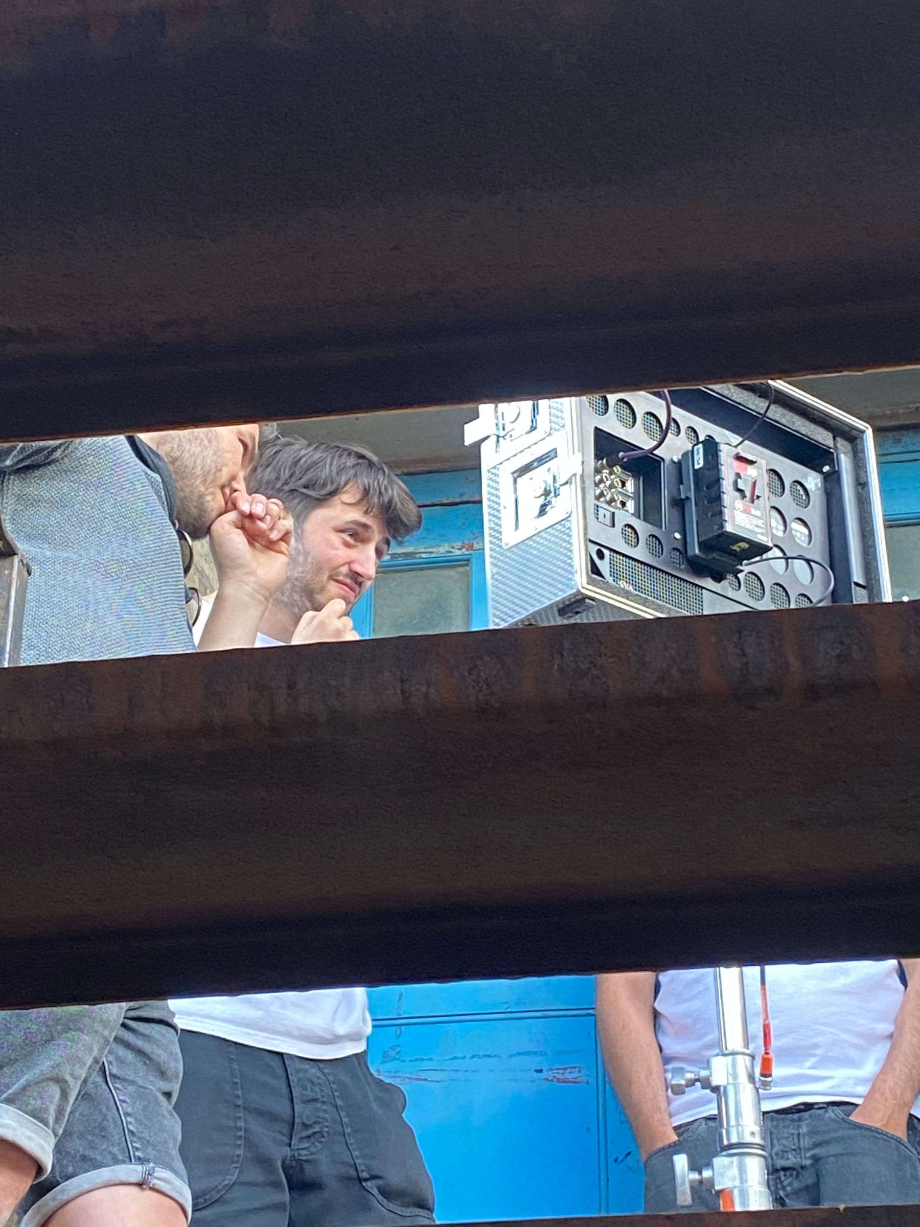 The camera monitors glimpsed between two steel beams on set